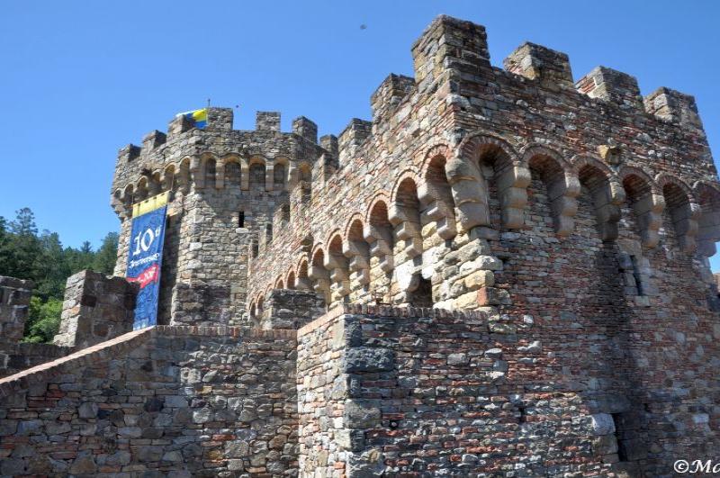 Castello Di Amorosa: каменные башни с арочными нишами под ясным небом